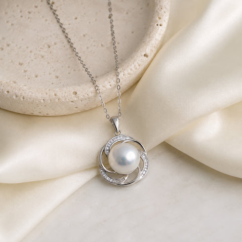 Pendant necklace with a 12–13mm Edison pearl set in a silver spiral halo with clear stones.