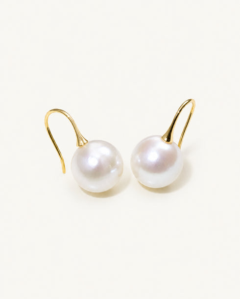 Pair of freshwater pearl hook earrings, 10–11mm with gold-tone hooks on white background