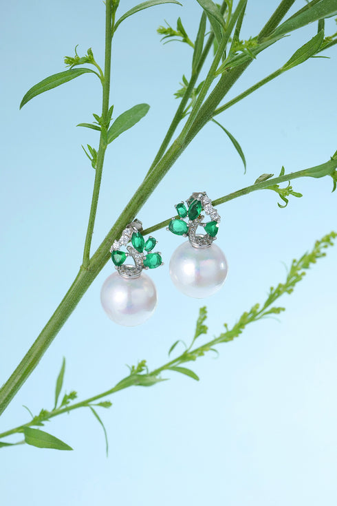 Pair of 12-13mm white pearl drop earrings with emerald-green zirconia accents in a silver setting