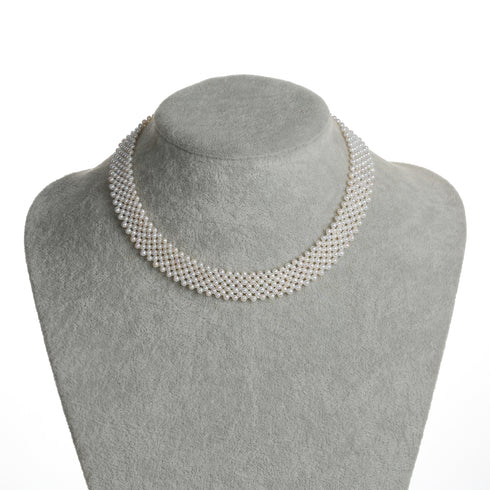 3-4mm white freshwater pearl multi-layered necklace on a gray display bust