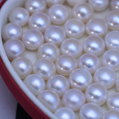 Earrings: white freshwater pearl studs in a red jewelry box with dozens of lustrous pearls