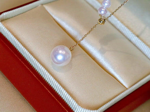 Akoya pearl pendant necklace on an 18K gold chain with white lustrous pearls in a satin jewelry box.