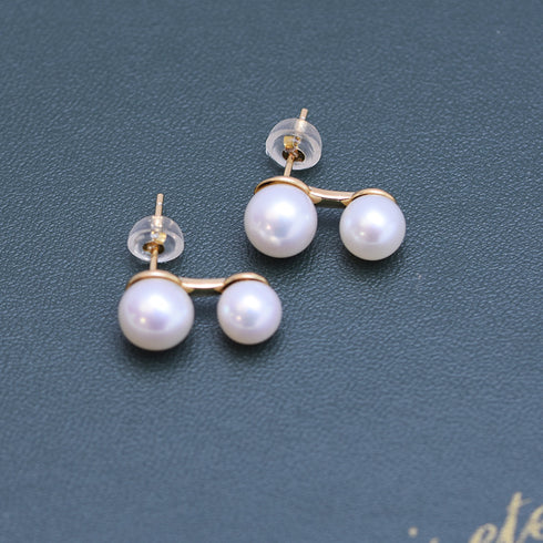 Pearl earrings with dual 6–8mm freshwater pearls on a curved gold-tone bar