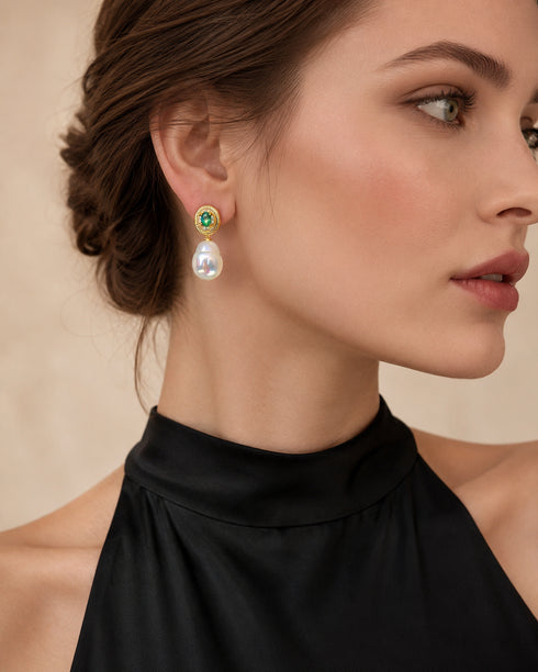 Earrings with gold-tone circular top featuring an emerald accent and a dangling baroque freshwater pearl drop