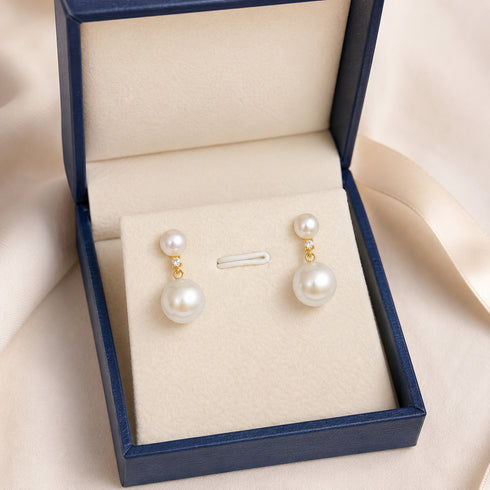 Earrings: pair of 9–10mm freshwater pearl duo-drop earrings in gold settings with crystal accents, displayed in a navy box.