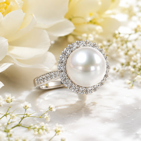 Ring featuring a large white South Sea pearl encircled by a halo of cubic zirconia stones on a silver band