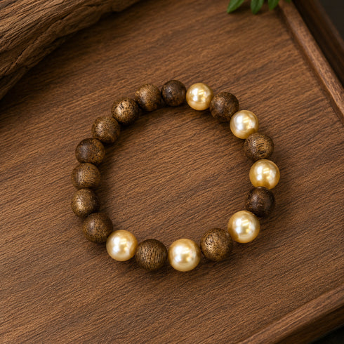 Agarwood & Golden South Sea Pearl Stretch Bracelet by House Of Pearls, with brown wood beads and golden pearls.