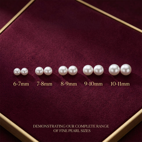 Grey button freshwater pearl stud earrings displayed as a row of white pearls on burgundy velvet.