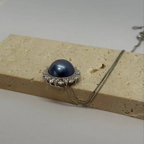 Pendant necklace: blue Mabe pearl halo with silver setting, House of Pearls.