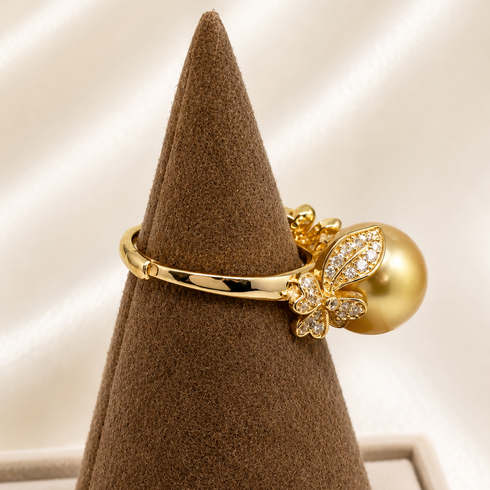 Ring featuring a gold band, 11–12mm Golden South Sea pearl, pavé-diamond floral motif, and elegant shine
