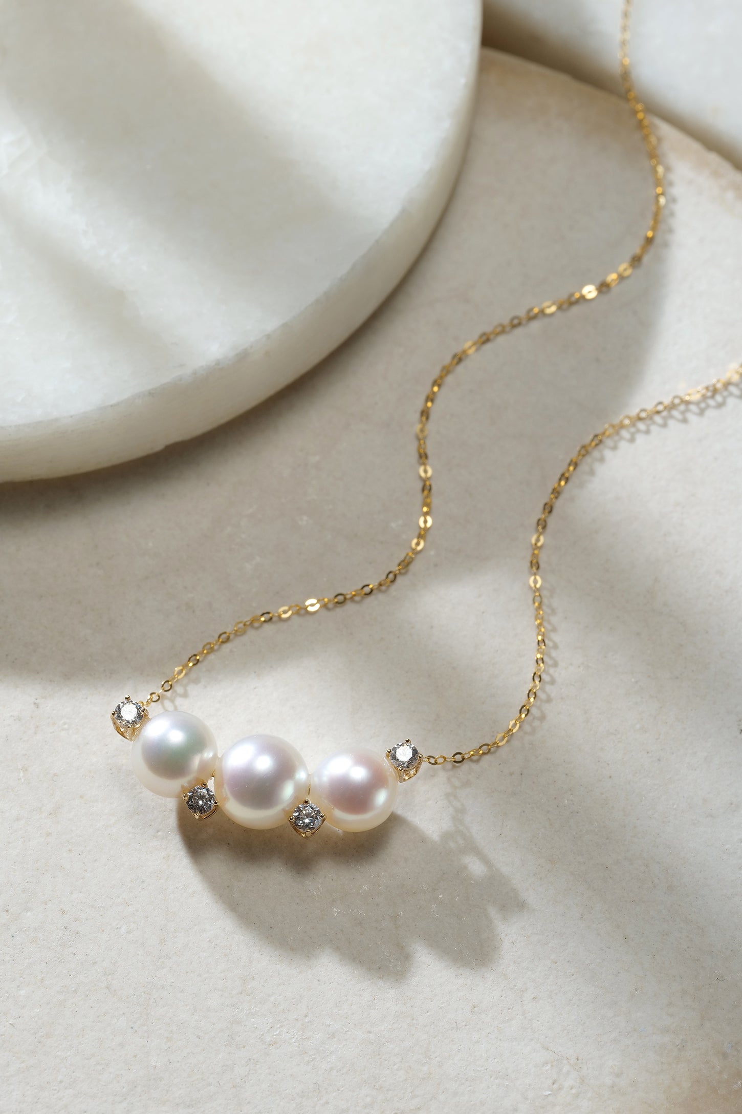 Necklace with 7–9mm Akoya pearls and cubic zirconia accents on an 18K gold chain.