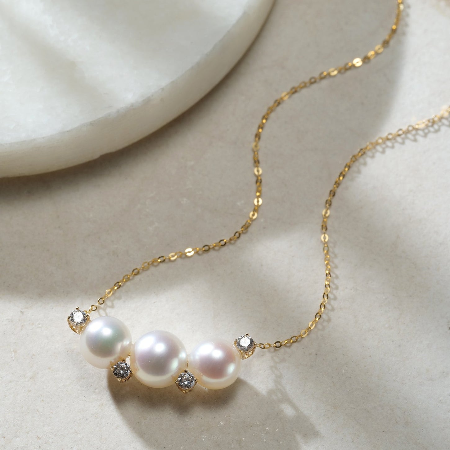 Necklace with 7–9mm Akoya pearls and cubic zirconia accents on an 18K gold chain.