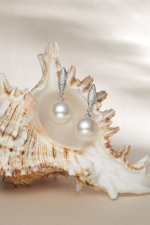 Earrings: 11–12mm freshwater pearl drops with marquise zirconia pave accents in silver-tone metal, pair.