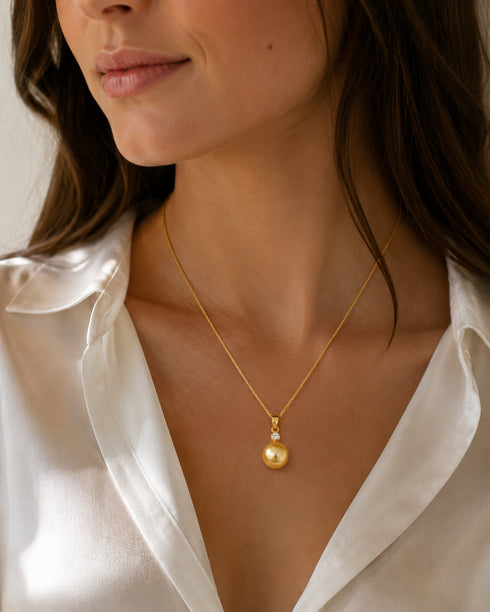 Mary pendant necklace featuring a golden South Sea pearl with diamond accent on an 18K gold chain