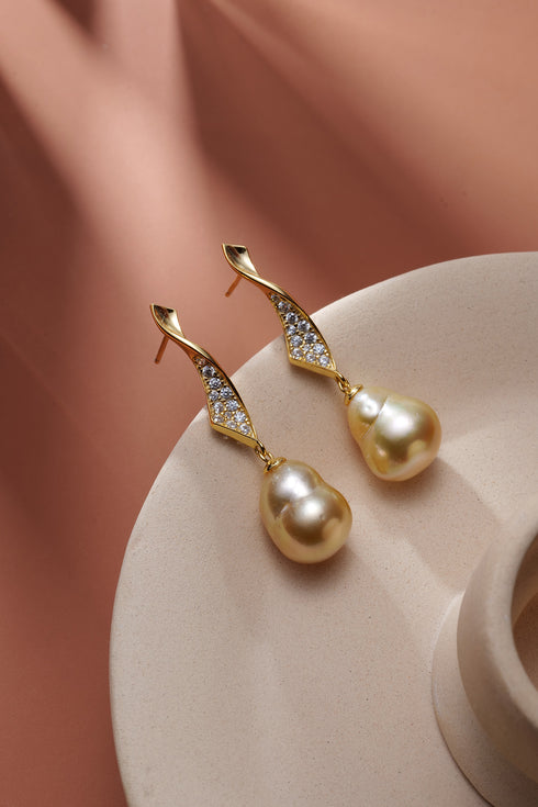Pair of drop earrings with 11–12mm golden South Sea baroque pearls and diamond-studded gold wave accents.