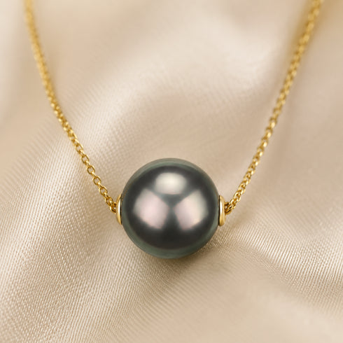 Tahitian pearl floating pendant necklace with a dark gray pearl on a gold chain.