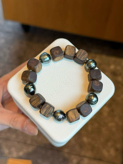 Agarwood & Golden South Sea Pearl stretch bracelet with dark wooden cube beads and blue-green pearls.