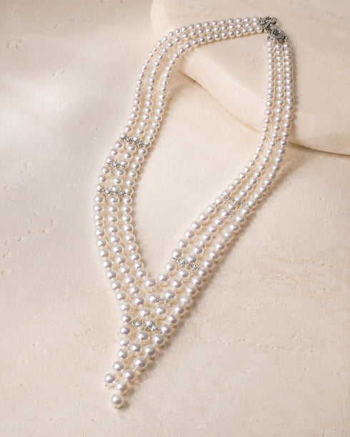 V-Shaped Aurora Pearl Sweater Necklace with multiple pearl strands and crystal spacers on a pale background