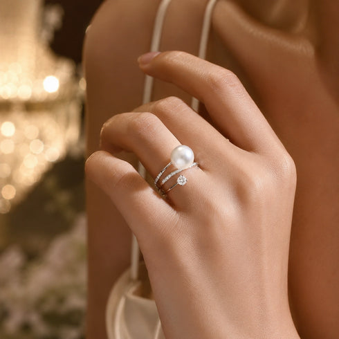 Pearl ring set: 8-9mm Akoya pearl with diamond-accent bands in silver-tone, worn on finger (2 rings)