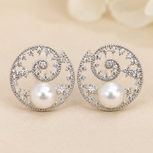 Pair of silver-tone circular filigree earrings with crystal accents in a floral wave motif and 7–8mm Akoya pearls.
