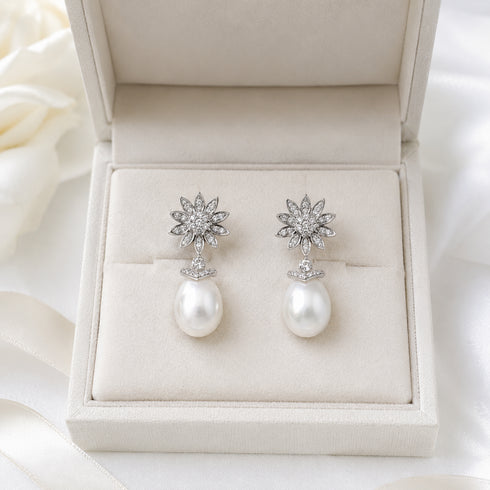 Earrings: Flora drop earrings featuring a flower-diamond cluster above white South Sea oval pearls