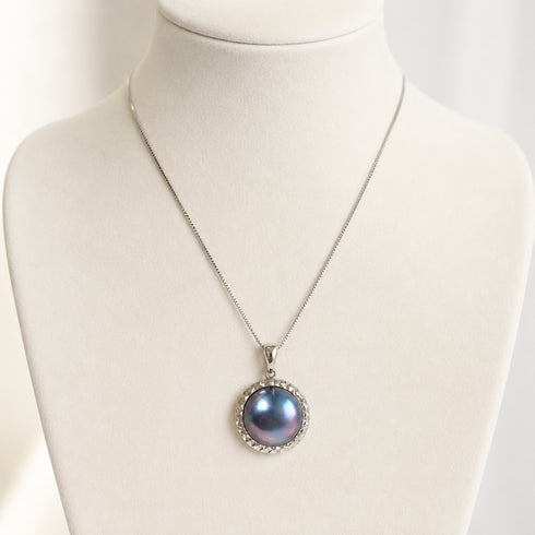 Blue mother-of-pearl statement pendant necklace on a silver chain with a textured bezel