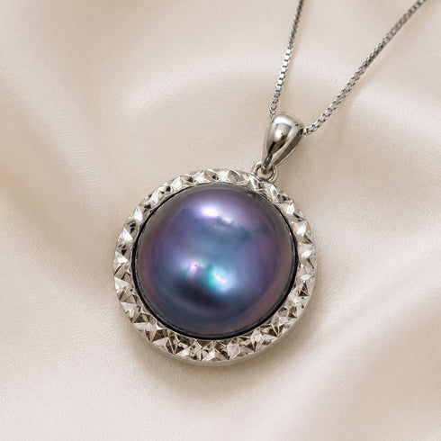 Blue mother-of-pearl statement pendant necklace with a textured, faceted silver frame on a silver chain.