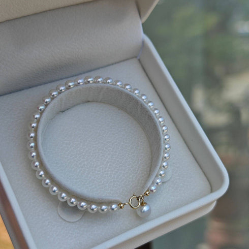 Dainty White Freshwater Pearl 18K Gold Bracelet with a gold clasp, shown in a white jewelry box