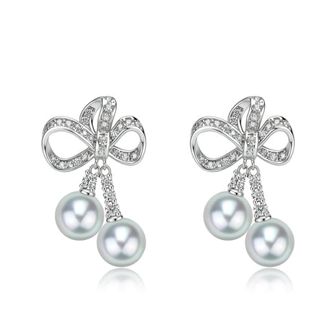 Earrings: House Of Pearls XM Celestial Bow Duo Drop with crystal-studded silver bow and blue Akoya pearls (pair).