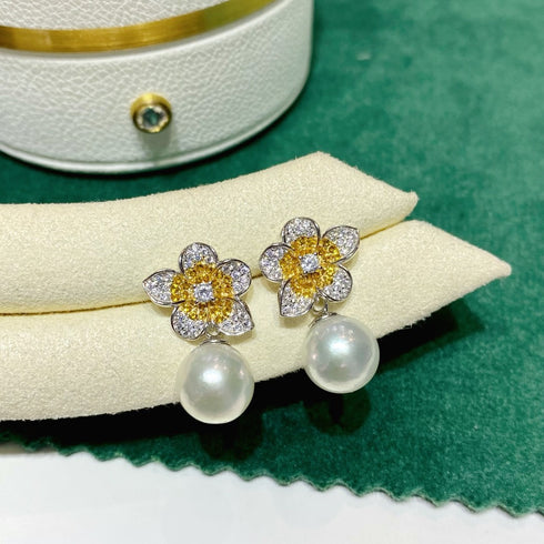 Flower-shaped freshwater pearl earrings set with diamond-studded petals, yellow centers, and pearl drops