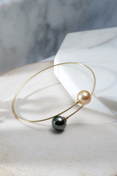Two Tahitian black pearl pendant necklaces on gold hoops; dark and golden pearls