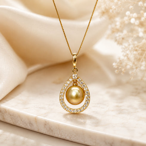 Gold necklace with teardrop pendant featuring a Golden South Sea pearl set in a CZ-studded frame