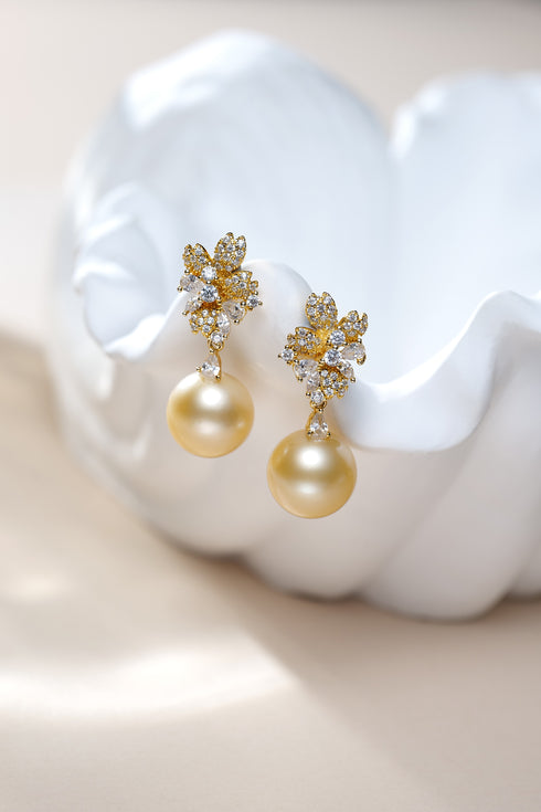 Earrings: 10–11mm Golden South Sea Pearl Flora Bloom Drop by House Of Pearls XM; diamond floral fronts, pearl drops.