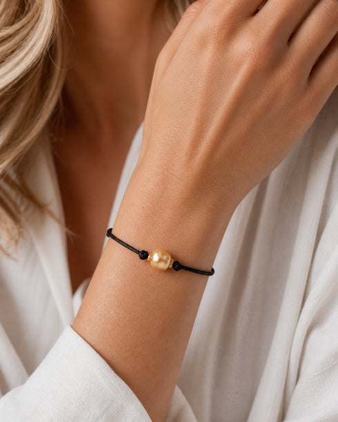 Bracelet: Golden South Sea baroque pearl on a knotted black leather cord, adjustable.
