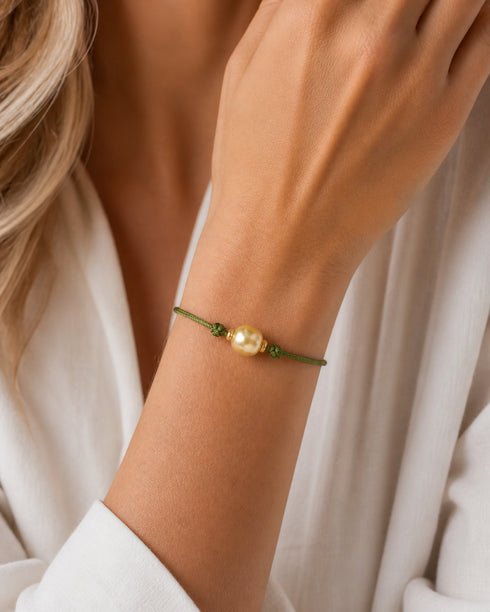 Bracelet: green knotted adjustable cord with a golden South Sea Baroque pearl bead.