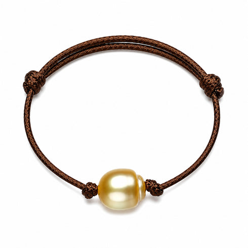 Leather bracelet featuring a golden South Sea baroque pearl on a brown knotted cord, adjustable.