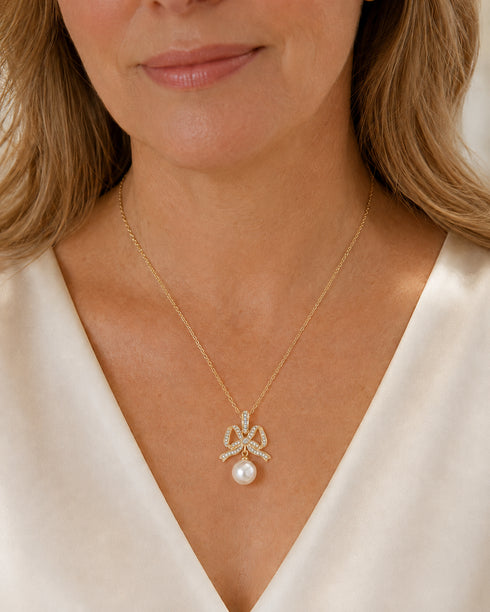 Bowknot pendant necklace by House of Pearls-TA with CZ accents and a 10-11mm freshwater pearl on a gold chain.
