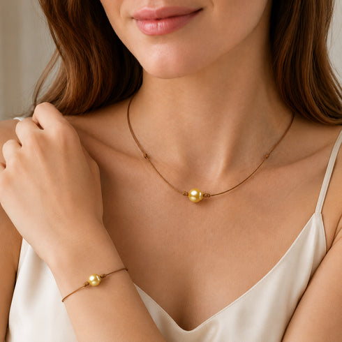 Two-piece jewelry set: golden South Sea pearl knotted leather bracelet and necklace on tan cord.
