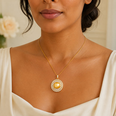 Necklace with a 12–13mm golden South Sea pearl pendant surrounded by a crystal halo on a slim gold chain.