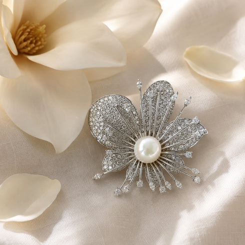Orchid brooch with 10–11mm freshwater pearl center, silver-tone pave crystals.
