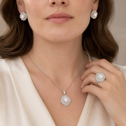 Jewelry set with white freshwater pearl and zirconia accents; includes earrings, pendant necklace, and ring in silver.