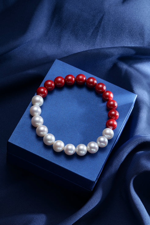 Bracelet with 8mm cinnabar red beads and freshwater pearls on a blue satin display