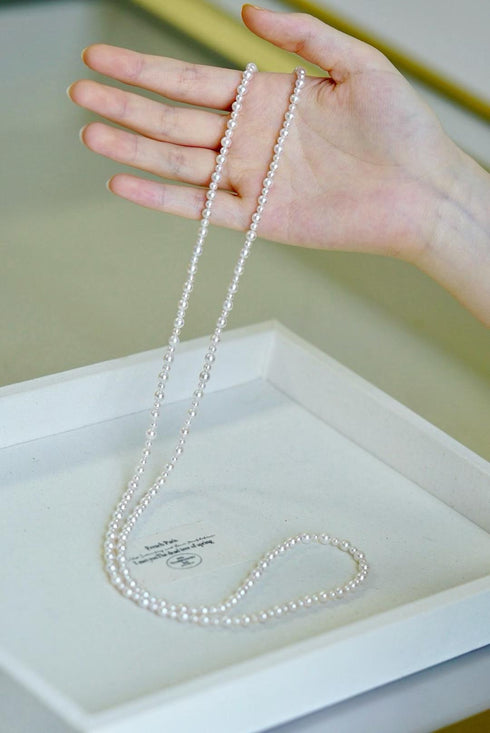 Akoya Seawater Pearl Opera Necklace, two-strand white pearls displayed on a hand and tray