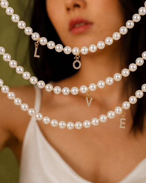 Dainty initial letter charm pendants with pavé cubic zirconia on white pearl bead chokers by House Of Pearls