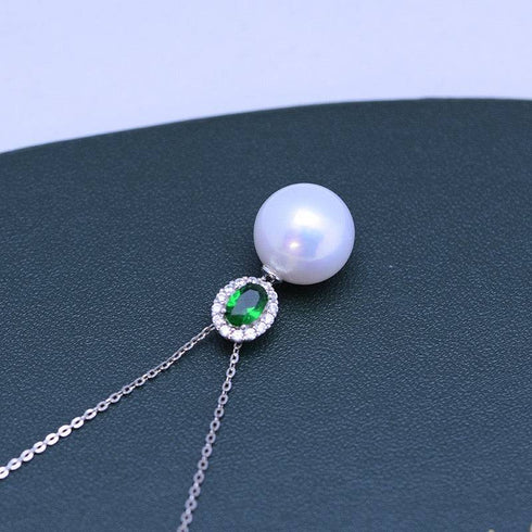 Pearl pendant necklace with 11-12mm freshwater pearl and green gemstone, halo of clear stones on silver chain.