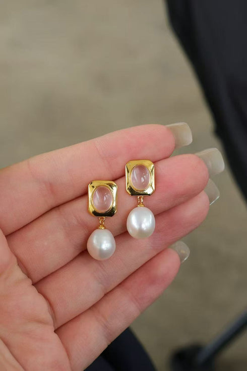 Earrings featuring rose quartz studs in gold-tone square settings with pearl drops.