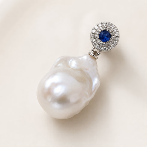Earrings by House Of Pearls: sapphire blue center with diamond halo and a white freshwater baroque pearl drop.