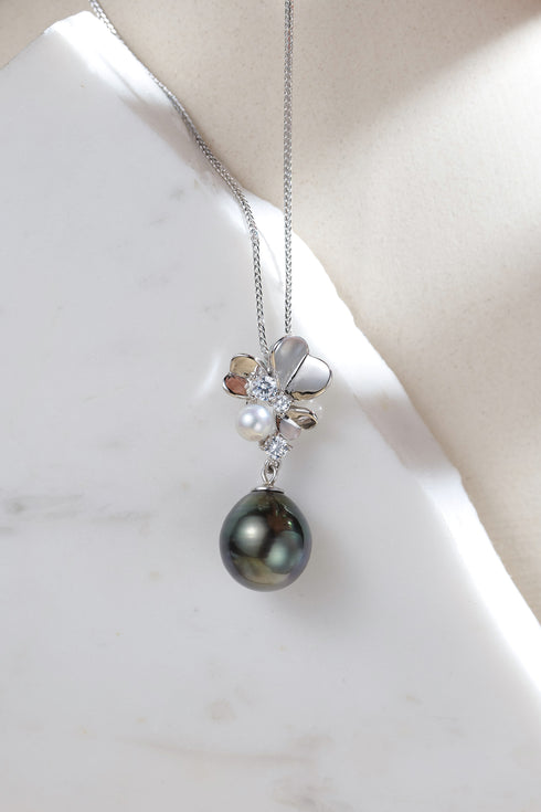 Necklace featuring Tahitian black pearl pendant on silver chain with diamond accents.