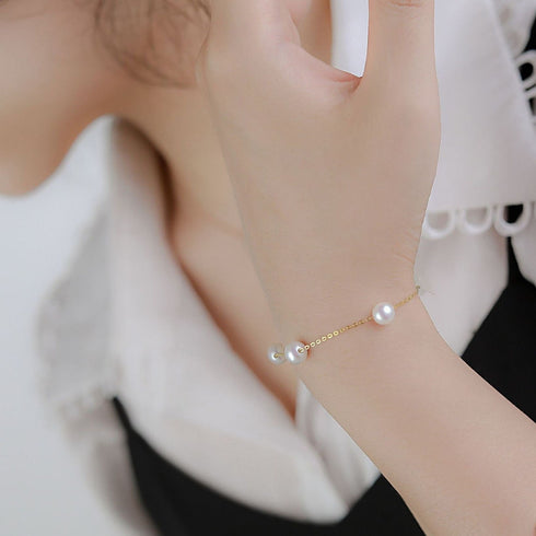Bracelet with white 7-8mm Chinese tincup pearls on a delicate 18K gold chain